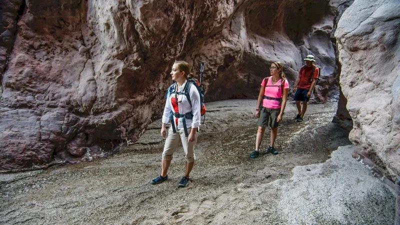 Hikers and a flowing stream in the canyon on the Arizona Hot Spring access trail; the bathing area is not shown